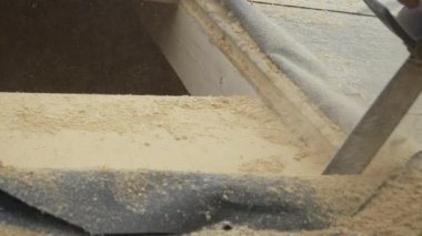 Müteahhit çatı penceresi için duvarda bir delik açmak için testere kullanıyor..