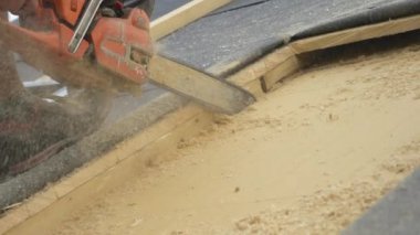 İşçi tavan penceresi montajı sırasında çatıda elektrikli testereyle bir açıklık açıyor.