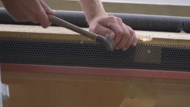 FERMER Travailleur marteaux clous lors de l'installation d'un maillage d'insectes le long du cadre en bois — Video