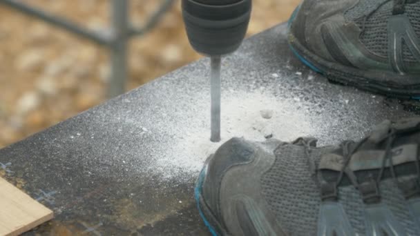 CLOSE UP: Unrecognizable builder bores a hole in the bitumen covered concrete. — Stock Video