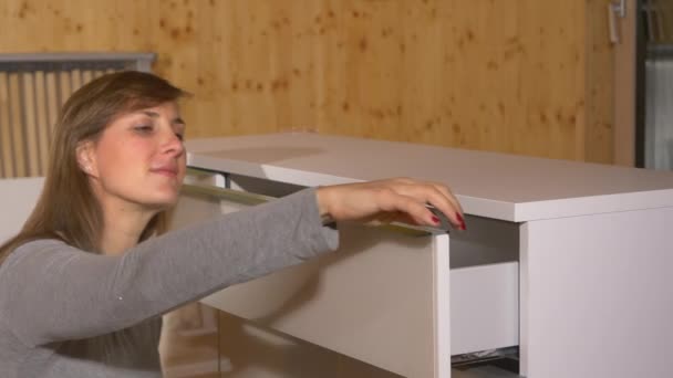 CERRAR: La mujer quita la lámina de plástico del cajón superior de un nuevo tocador. — Vídeos de Stock