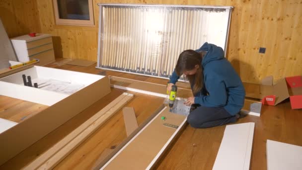 女性在装修卧室时将金属碎片和木板拧在一起 — 图库视频影像