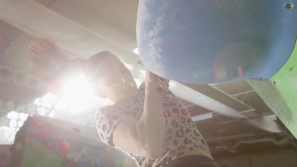 CLOSE UP, DOF: Woman uses a large blue boulder to ascend a challenging route. — Stock Video