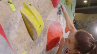 Güçlü, beyaz bir kadın, uzun, mavi bir çimenliğe doğru tırmanıyor..