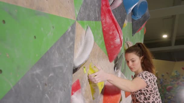 CLOSE UP: Sportlerin klettert in Kletterhalle eine anspruchsvolle Route hinauf. — Stockvideo