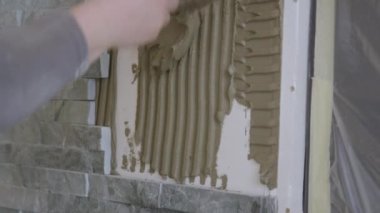 Müteahhit, doğal taş fayanslar döşerken duvara havan topu atıyor..