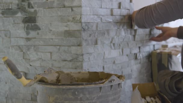 CLOSE UP: Builder mäter upp en sten kakel samtidigt som kakel på väggen. — Stockvideo