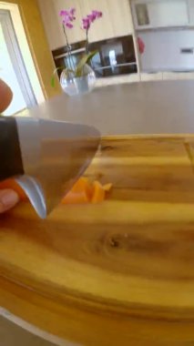 Paslanmaz çelik bıçak kullanan biri organik bir havucu doğruyor..