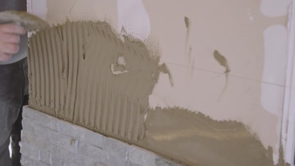 CHIUSURA, DOF: Lavoratore applica cemento bagnato sul muro con una vecchia spatola. — Video Stock