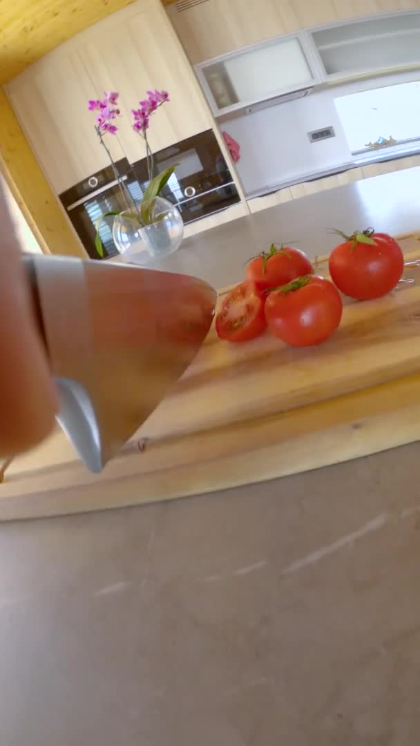 VERTICAL: Il coltello da chef affilato taglia un delizioso pomodoro biologico in piccoli spicchi. — Video Stock