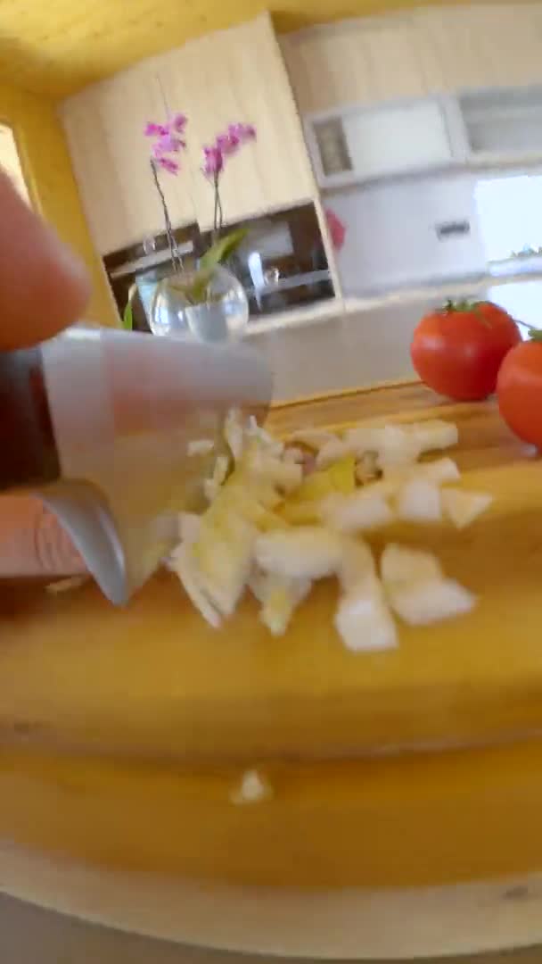 VERTICAL: Disparo detallado de un cuchillo de acero picando cebollas en la tabla de madera. — Vídeos de Stock