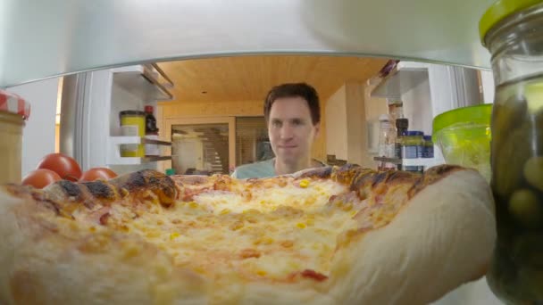 FERMER : L'homme au régime succombe à la tentation et sort une pizza de son réfrigérateur. — Video