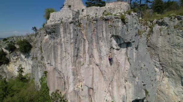 AERIAL: Espectacular paisaje rodea a una joven que aprende a escalar la cuerda superior. — Vídeos de Stock
