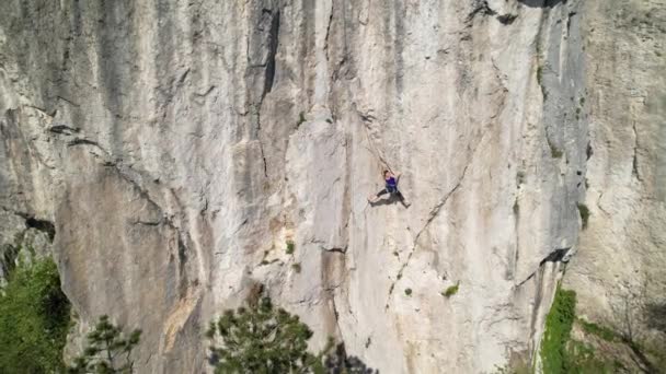 DRONE: Bergsteigerin, die Hochseil lernt, sucht Halt in der Naturwand. — Stockvideo