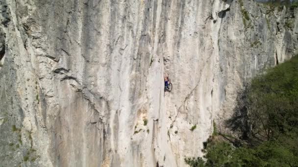 AERIAL: Drone view of a rock climber looking for a hold while learning to climb — Stock Video