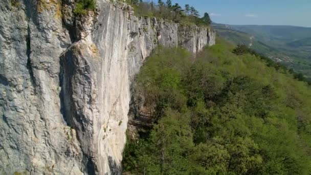AERIAL Drone zicht op een vrouwelijke klimmer top touwen een torenhoge klif in Crni Kal — Stockvideo