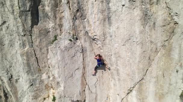 AERIAL: Ιπτάμενη θέα του τοπίου γύρω από γυναίκα αναρρίχηση βράχου στη Σλοβενία — Αρχείο Βίντεο