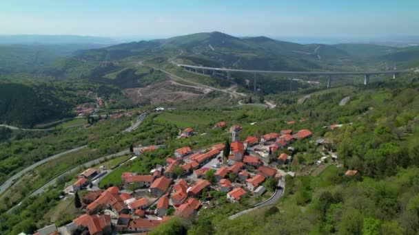 AEREO Sorvolando una tranquilla cittadina nei pressi di un ponte autostradale che attraversa la verde valle — Video Stock