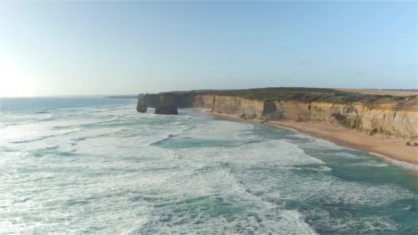 DRONE : Les vagues infinies de l'océan roulent vers les 12 Apôtres rivage par une journée ensoleillée. — Video