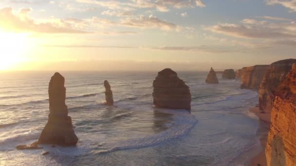 AERIAL: Gouden ochtend zon verlicht kliffen aan de kust van Australië. — Stockvideo