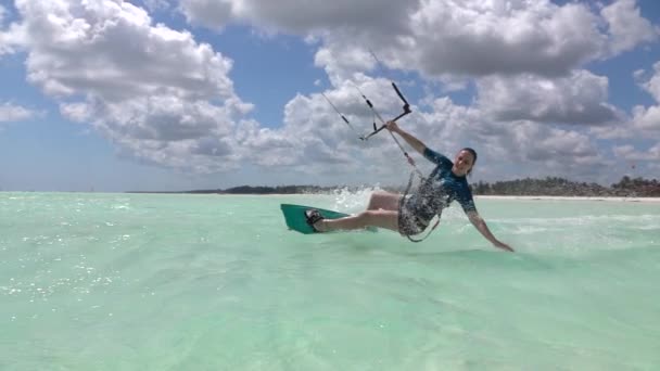 CLOSE UP: Fit female kiteboarder surfs around the blue lagoon in Zanzibar. — Αρχείο Βίντεο