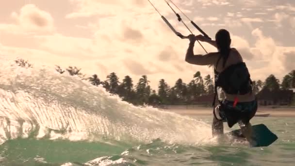 CLOSE UP: Kiteboarder doing a trick high in the air while surfing in Tanzania — Vídeos de Stock