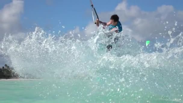 SLOW MOTION: Kitesurfer attempting trick crashes into the turquoise ocean water. — Vídeos de Stock