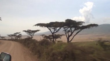 POV: Driving along an empty road with a view of spectacular Ngorongoro crater.