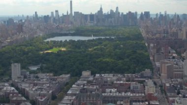 AERIAL: Flying across the spectacular green Central Park in the middle of NYC.
