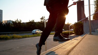 Tanınmayan bir işadamı gün doğumunda merdivenlerden koşarak çıkar..