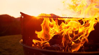 Yakıt ateşin üzerine dökülüyor, kömür ızgarasının içinde yanıyor..