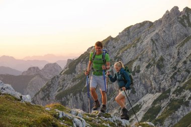 Carefree male and female tourists exploring the mountains in the early morning.