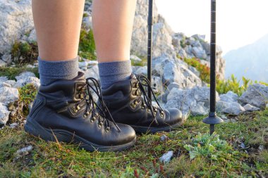 LOW ANGLE: Woman trekking in the Alps stops at the summit to watch the sunrise.