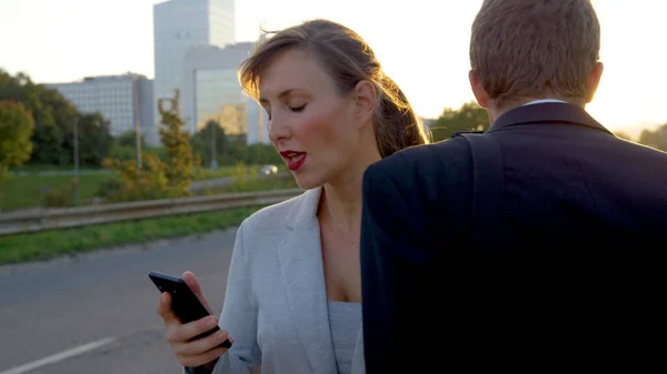 CLOSE UP: Beautiful businesswoman looking at her smartphone crashes into yuppie. —  Fotos de Stock