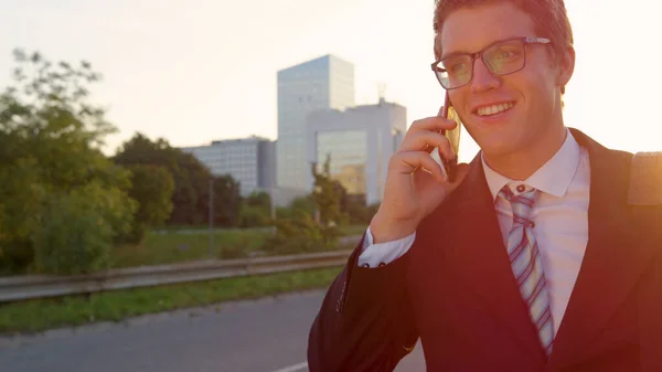 LENS FLARE: Happy businessman calling his colleagues to meet him after work. — стоковое фото