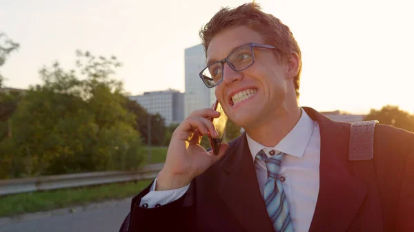 CLOSE UP: Young businessman gets good news over phone while walking through city — Stock Photo, Image