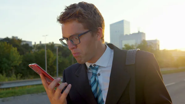 LENS FLARE: Stressed young man gets angry after getting a phone call from work. — Stock Photo, Image
