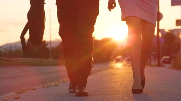 FAIBLE ANGLE : Homme et femme méconnaissables en talons hauts marchant jusqu'au travail au lever du soleil — Photo