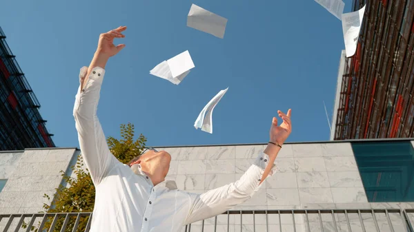 SLOW MOTION: Happy young man throws papers into the air after getting promoted. — Stock Photo, Image