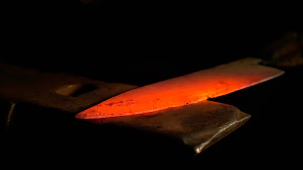 MACRO, DOF: Glowing hot metal blade is held on an anvil before being struck. — Stockfoto