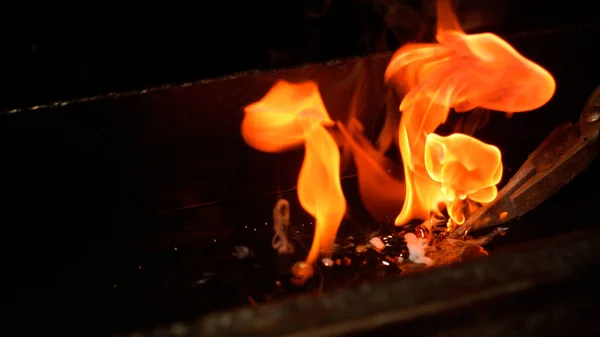 MACRO, DOF: Piękny ogień na świecącym ostrzu ugaszony gorącym olejem. — Zdjęcie stockowe