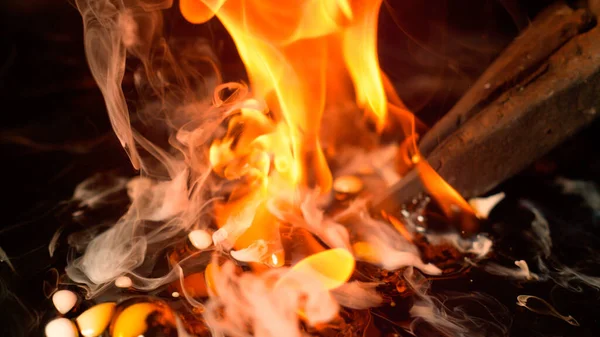 MACRO: Pinças de metal giram uma lâmina em óleo quente durante o processo de tratamento térmico. — Fotografia de Stock