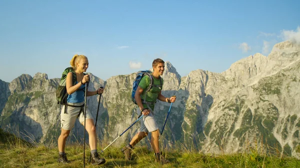 在阳光灿烂的夏日，一对矮小的游客夫妇在令人叹为观止的阿尔卑斯山中跋涉. — 图库照片