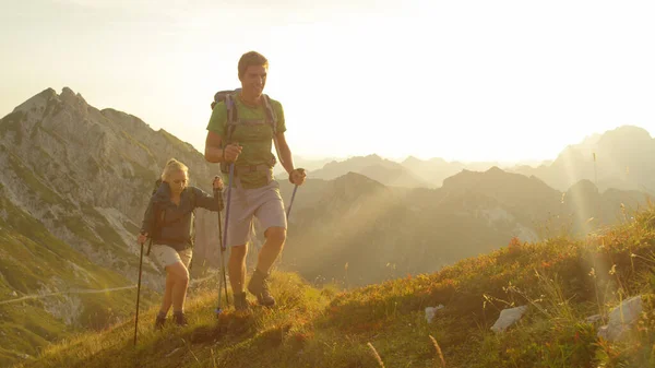 CHIUSURA: Buoni turisti che camminano tra le splendide montagne in una giornata estiva soleggiata. — Foto Stock