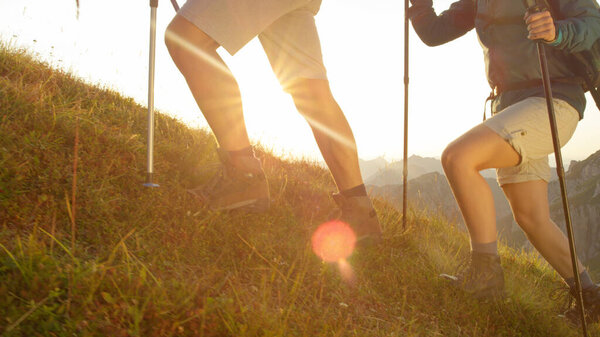 SUN FLARE: Young trekkers planting their poles in the grass while walking uphill