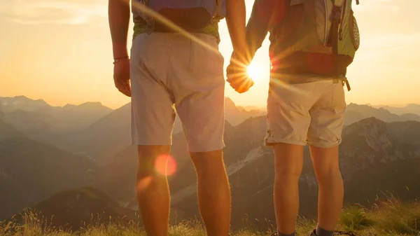 FERMER Femme et homme amoureux se tenant la main tout en observant le coucher du soleil dans les montagnes — Photo