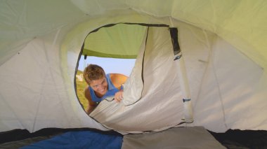 CLOSE UP: Thief gets excited after opening a tent set in the peaceful meadow.