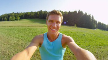 Neşeli bir adam güneşli bir bahar gününde, pitoresk çayırların etrafında döner..