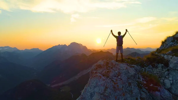 DRONE LENS FLARE: Goldene Morgensonne scheint auf den ekstatischen Mann beim Wandern. — Stockfoto