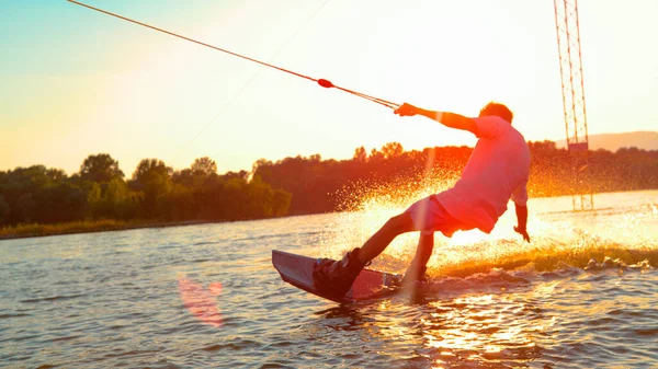SUN FLARE: Homem atlético irreconhecível acordando no lago ao pôr-do-sol dourado. — Fotografia de Stock
